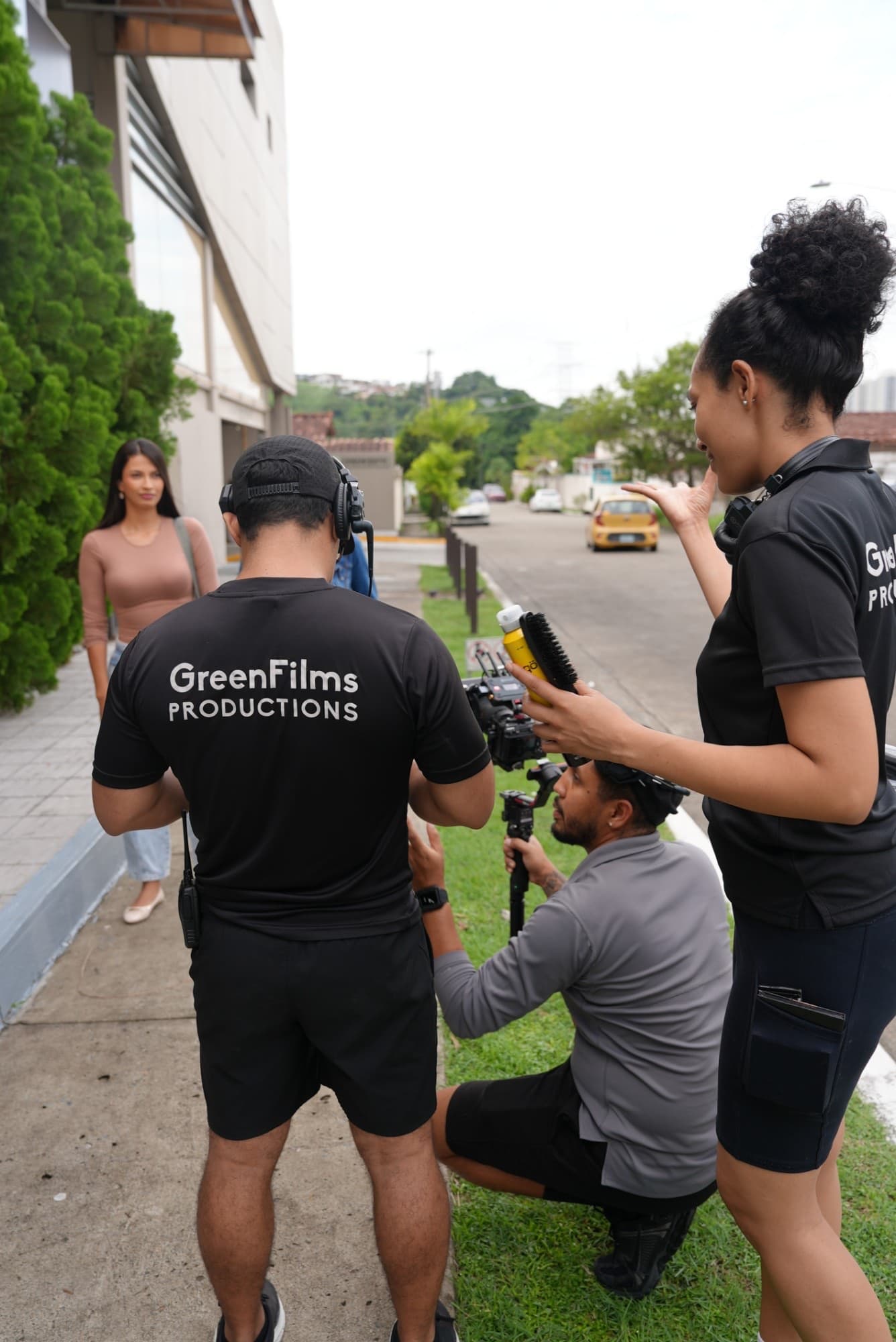 Equipo de Green Films Productions preparando una toma en exteriores: camarógrafo con estabilizador, maquillaje y una actriz esperando